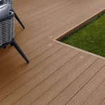 Brown wood-look composite decking next to grass.