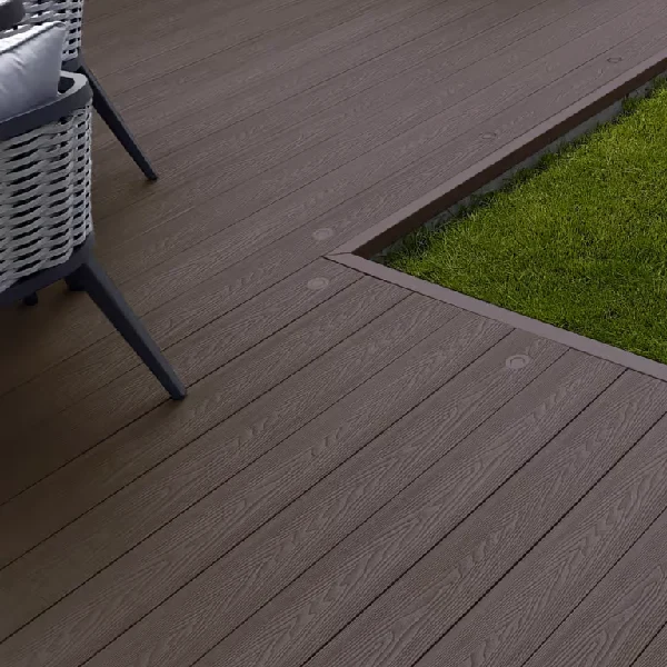 Dark brown composite decking next to grass.