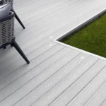 Light grey composite decking next to grass.