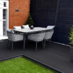 Outdoor dining set on dark composite decking and grass. (1)