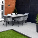 Outdoor dining set on light grey composite decking.